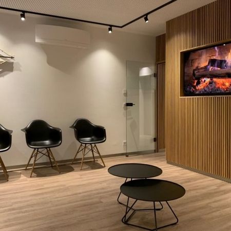 Modernes Wartezimmer mit Fernseher, gemütliche Atmosphäre für wartende Gäste.