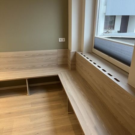 Modernes Wartezimmer mit Fenster, gemütliche Atmosphäre für wartende Gäste.
