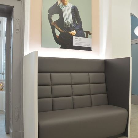 Eine Couch in einem Raum mit einem Gemälde an der Wand.