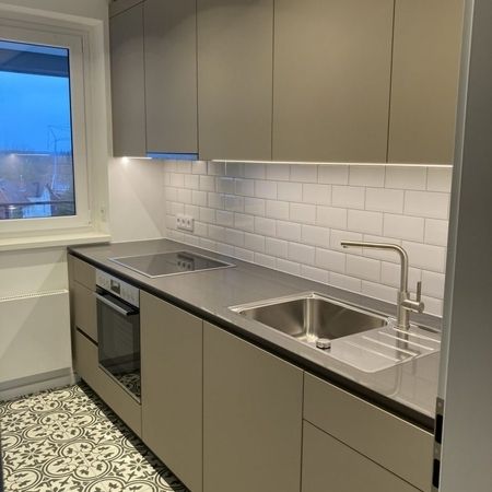 Eine moderne Küche mit Spüle, Ofen und Mikrowelle, die funktional und einladend wirkt.