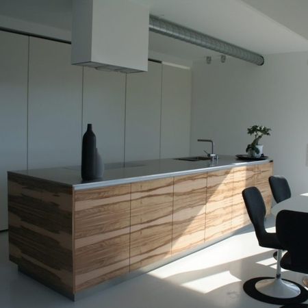 Moderne Küche mit einem Holzinsel und Stühlen, die einladend und stilvoll gestaltet ist.