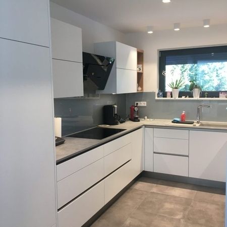 Eine moderne Küche mit weißen Schränken und einem eleganten Spülbecken.